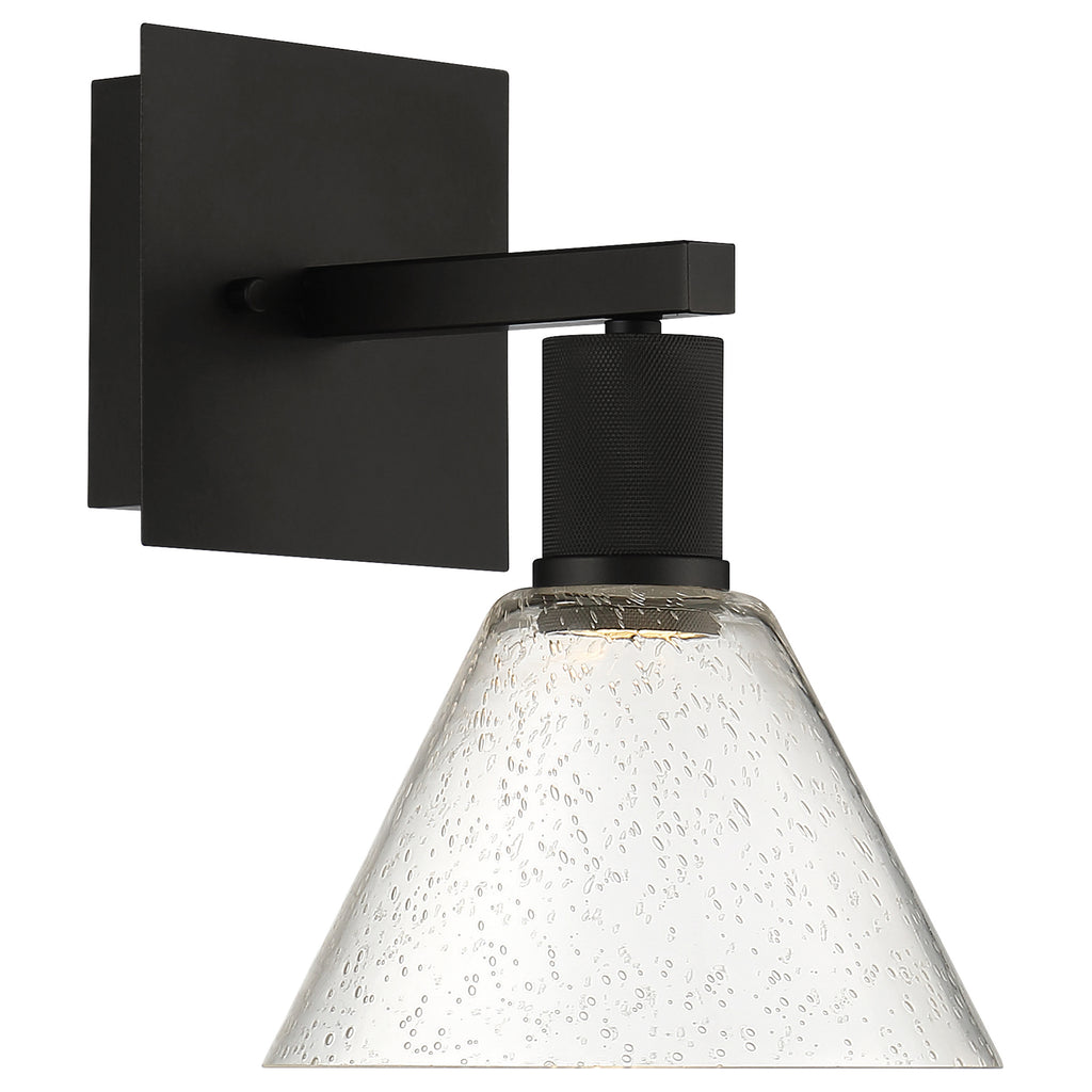 The Access Lighting Port Nine Martini LED Wall Sconce features a matte black metal base and arm, paired with a cone-shaped seeded (bubbled-textured) glass shade, and uses 9W LED lighting.