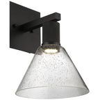 The Port Nine Martini LED Wall Sconce by Access Lighting features a matte black metal base and a clear, cone-shaped seeded glass shade with bubble details.