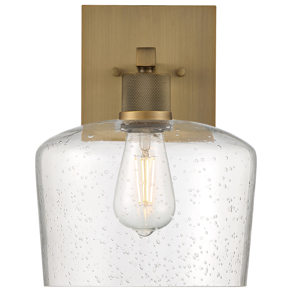 Port Nine Chardonnay LED Wall Sconce by Access Lighting features an antique brushed brass backplate, a clear seeded glass shade, and a 7W LED that evokes the look of a vintage-style filament bulb.