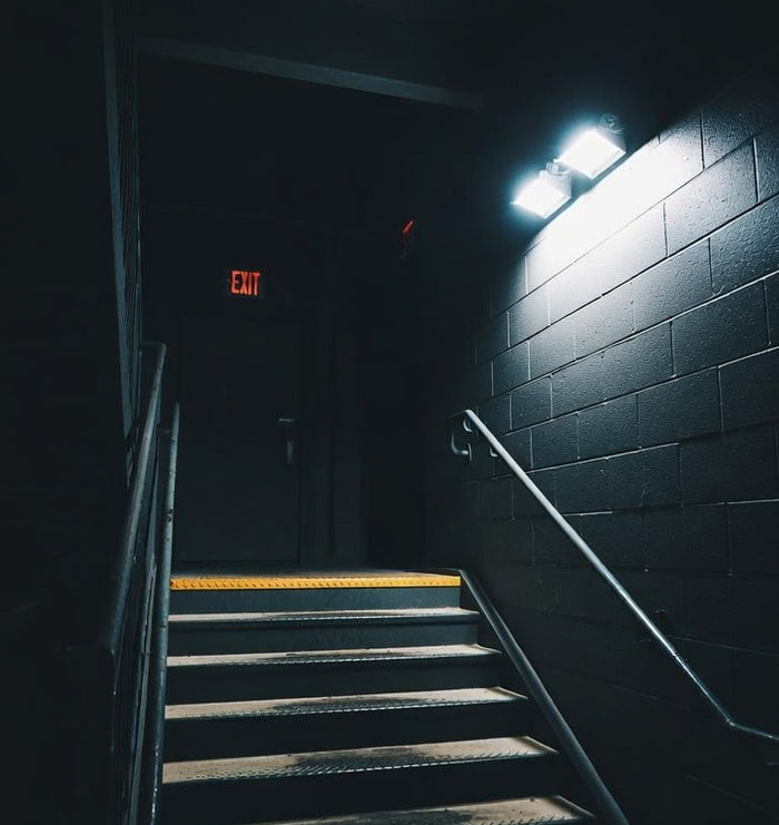 Emergency twin-head light and illuminated exit sign in a commercial stairwell