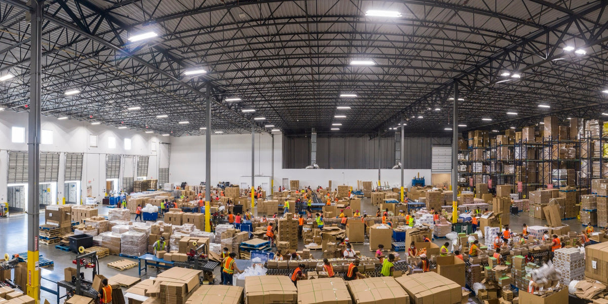 Warehouse lit by rows of linear LED high bay fixtures